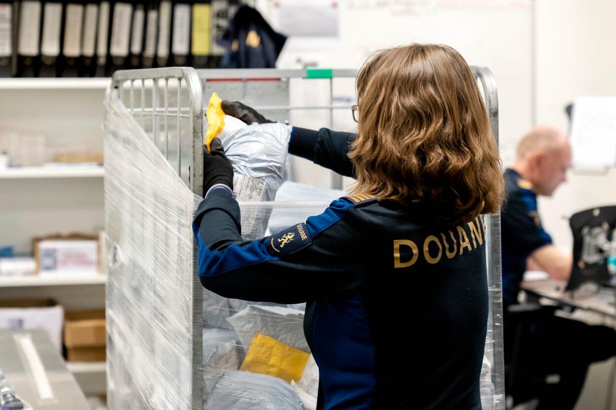 Een Douanier controleert pakketjes in het sorteercentrum