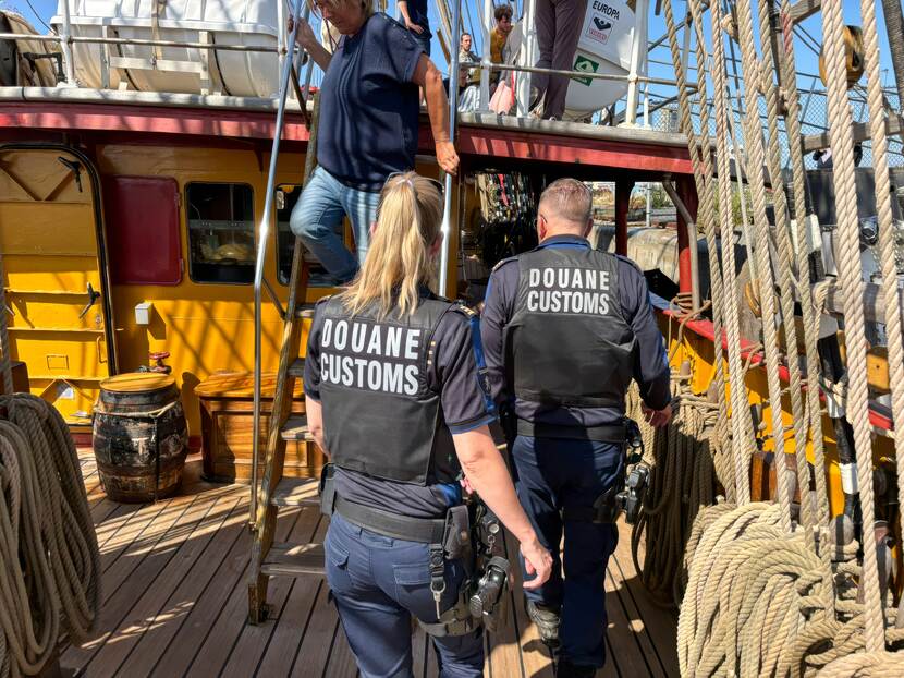 De Douane loopt over het dek van het schip