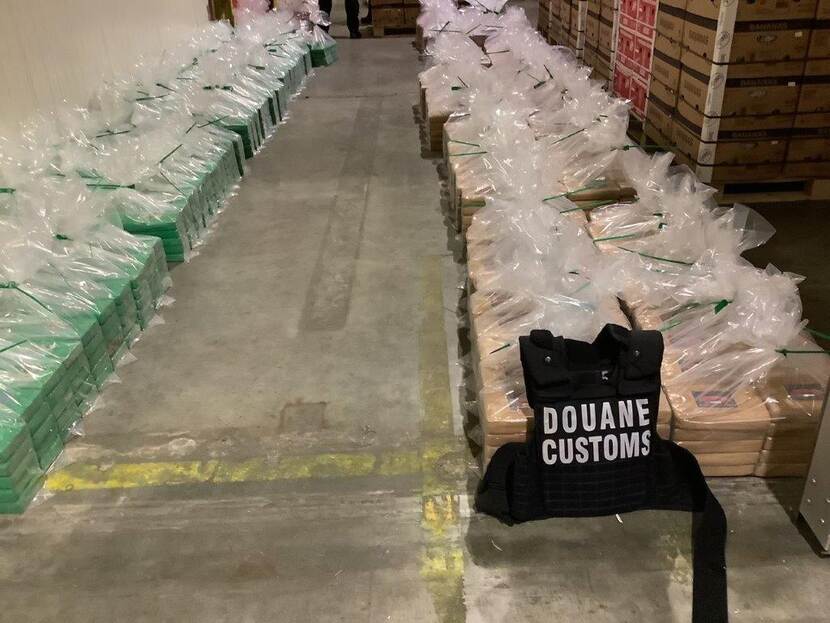 pakketten cocaïne uitgestald met Douane-vest op voorgrond